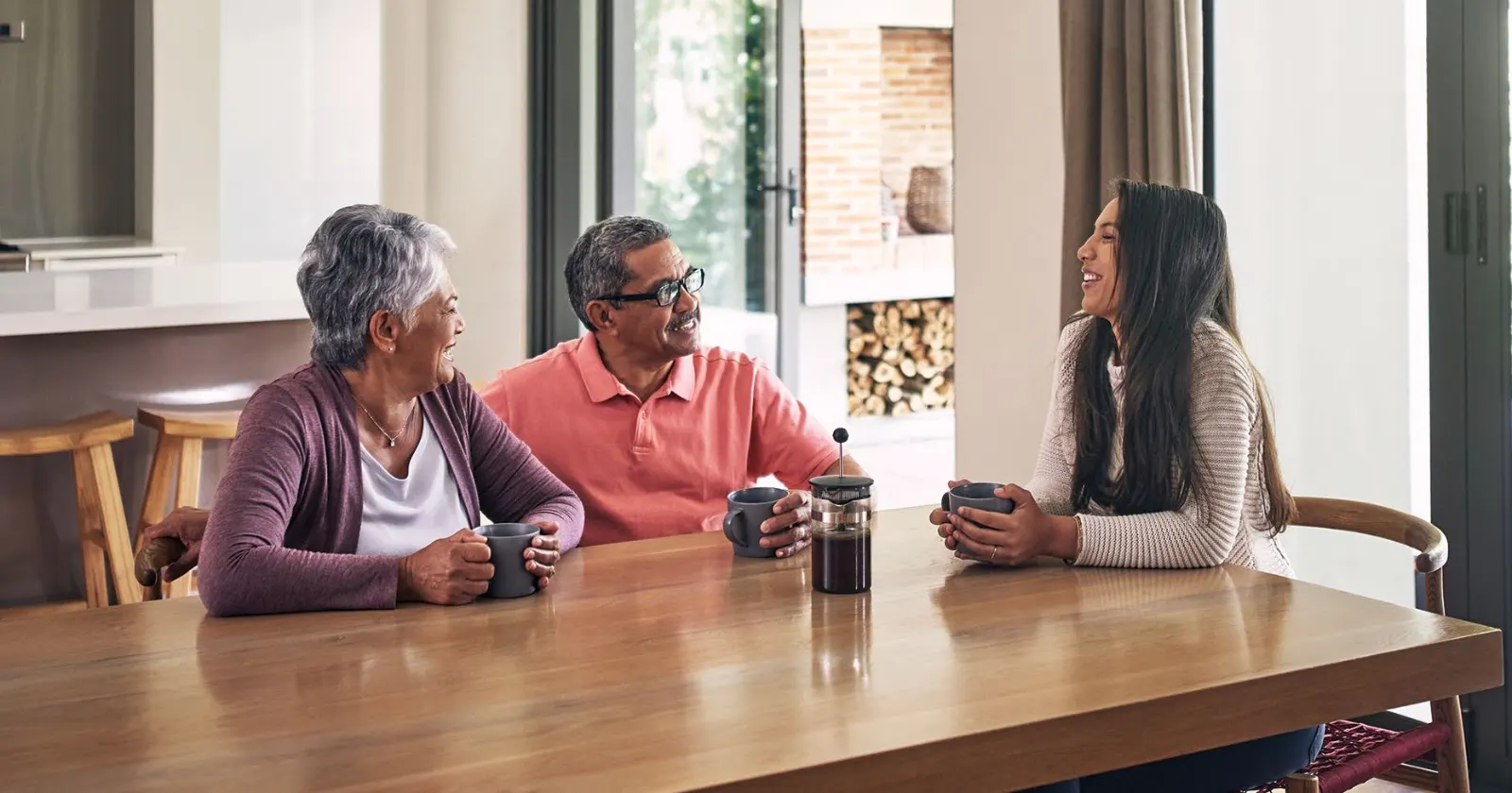 Three generations of a family talking at a dining table.